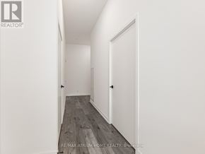 Toronto (South Parkdale) condo for rent - A hallway with a wooden floor and white walls.