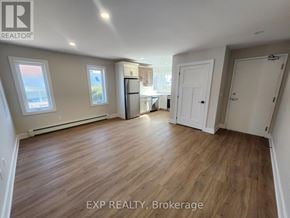 North Grenville multi-family for rent - A room with wooden flooring and white walls, with a window on the left side.