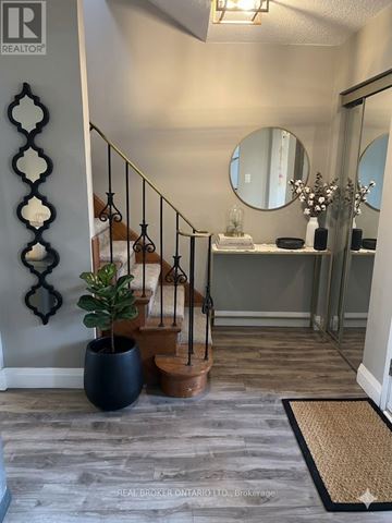 Kitchener townhouse for rent - A living room with a grey couch and a clock on the wall.