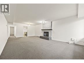 North Vancouver apartment for rent - A spacious living room with a fireplace and a carpeted floor.