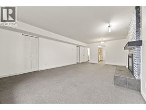 North Vancouver apartment for rent - A spacious room with a fireplace and a carpeted floor.