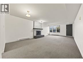 North Vancouver apartment for rent - A spacious living room with a fireplace and a large window.