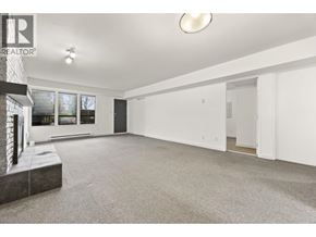 North Vancouver apartment for rent - A large, empty room with a carpeted floor and a window on the left side.