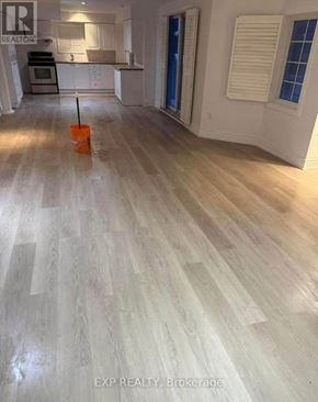 Vaughan (East Woodbridge) apartment for rent - A room with wooden flooring and a brokerage sign.