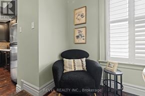 Mississauga (Streetsville) multi-family for rent - A black chair with a striped pillow is in front of a wall with two framed pictures on it.