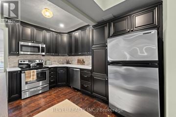Mississauga (Streetsville) duplex for rent - A modern kitchen with black cabinets and stainless steel appliances.