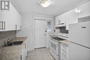 Hamilton (Stipley) multi-family for rent - A white kitchen with a sink and a refrigerator.