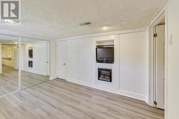 Toronto (O'connor-Parkview) apartment for rent - A spacious living room with a television and a fireplace.