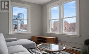 Oshawa (O'neill) apartment for rent - A living room with a grey sofa and a glass table.