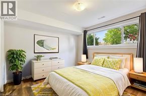 Welland apartment for rent - A bedroom with a bed, nightstand, and a potted plant.