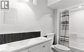 Welland apartment for rent - A white bathroom with a toilet, sink, and bathtub.