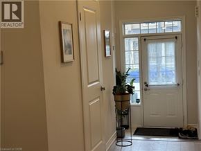 Brantford townhouse for rent - A hallway with a door and a plant on a stand.