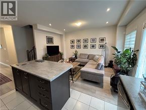 Brantford townhouse for rent - A living room with a grey sofa and a grey kitchen island.