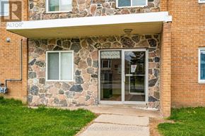 Orangeville condo for rent - A stone building with a glass door and windows.