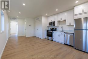 Port Colborne (Sugarloaf) multi-family for rent - A kitchen with white cabinets and stainless steel appliances.