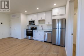 Port Colborne (Sugarloaf) multi-family for rent - A kitchen with white cabinets and stainless steel appliances.