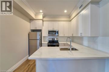 Hamilton apartment for rent - A modern kitchen with white cabinets and a white countertop.