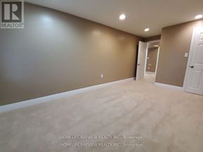 Newmarket (Stonehaven-Wyndham) apartment for rent - A room with beige walls and carpeting, with a doorway leading to another room.
