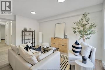 Windsor apartment for rent - A living room with a white couch and a wooden side table.