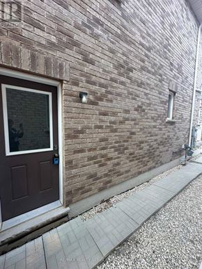 Brampton (Credit Valley) apartment for rent - A brown door is on a brick wall.