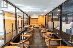Waterloo condo for rent - A long row of wooden chairs are lined up in a room with glass walls.