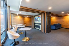 Waterloo condo for rent - A modern office space with a wood panelled wall and a television screen.