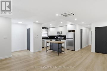 Pelham (Fonthill) duplex for rent - A modern kitchen with a dining table and chairs in a spacious room.