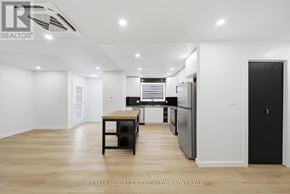 Pelham (Fonthill) duplex for rent - A spacious kitchen with a dining table and a refrigerator.