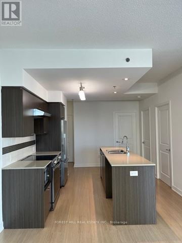 Toronto (Forest Hill South) house for rent - A modern kitchen with dark wood cabinets and a white island.
