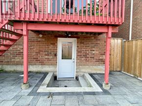 Whitchurch-Stouffville (Stouffville) apartment for rent - A white door is in a brick wall with a red railing above it.