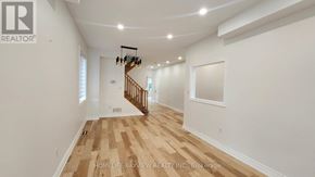 Richmond Hill (Oak Ridges) apartment for rent - A spacious room with wooden flooring and a staircase.