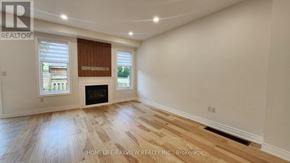 Richmond Hill (Oak Ridges) apartment for rent - A spacious room with a fireplace and wooden flooring.