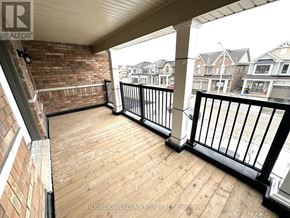 Barrie multi-family for rent - A balcony with a black railing and wooden floor.