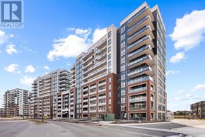 Clarington (Bowmanville) condo for rent - A large, modern multi-story building with a glass facade and a parking lot in front.