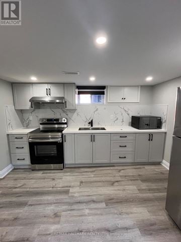 Toronto (Kennedy Park) apartment for rent - A kitchen with a refrigerator, oven, and sink.