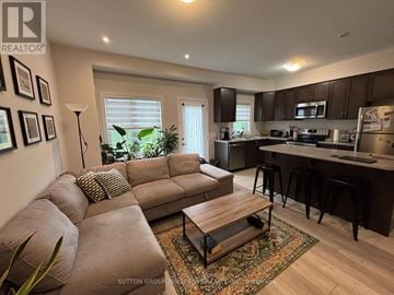 Brantford townhouse for rent - A living room with a brown couch and a coffee table.