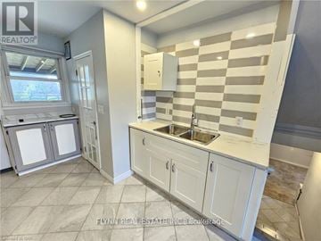 Welland (Lincoln/Crowland) apartment for rent - A kitchen with white cabinets and a checkered backsplash.