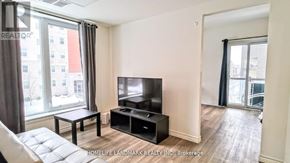 Waterloo condo for rent - A living room with a flat screen TV and a white couch.