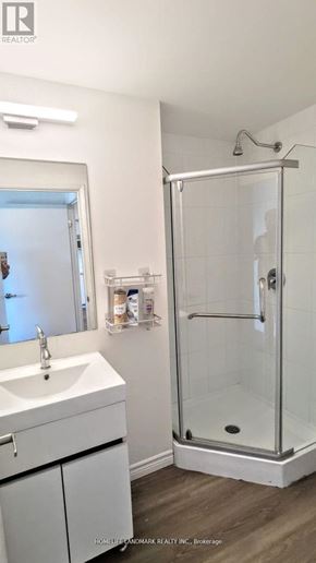 Waterloo condo for rent - A white bathroom with a sink, mirror, and shower.