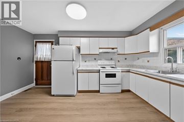 Kitchener apartment for rent - A kitchen with white cabinets and a refrigerator.