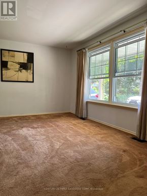 London North (North H) apartment for rent - A room with a carpeted floor, a window with curtains, and a framed picture on the wall.