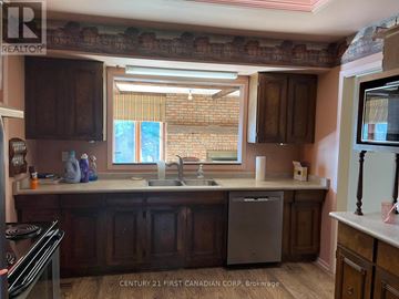 London North (North H) apartment for rent - A kitchen with wooden cabinets and a brick wall.