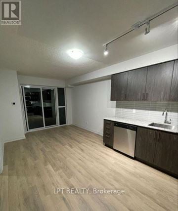 Toronto (Woburn) condo for rent - A kitchen with wooden floors and a sink.