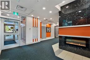Hamilton condo for rent - A hallway with a fireplace and a realtor sign on the wall.