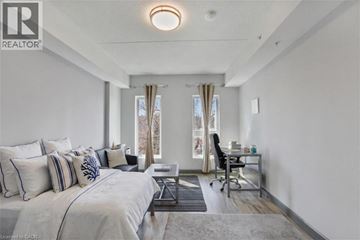 Hamilton condo for rent - A bedroom with a large bed and a desk with a chair.