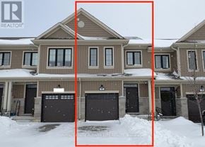 Zorra (Thamesford) townhouse for rent - A large house with a brown and beige exterior is surrounded by snow.