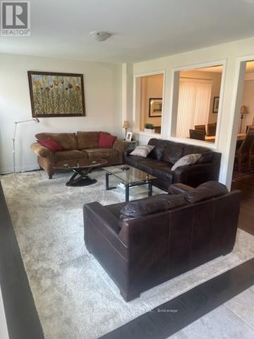 Hamilton (Waterdown) apartment for rent - A living room with a brown couch and a painting on the wall.