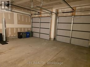 London East (East D) townhouse for rent - A garage with two doors and a black trash can.