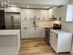 Ottawa apartment for rent - A kitchen with white cabinets and a stainless steel refrigerator.