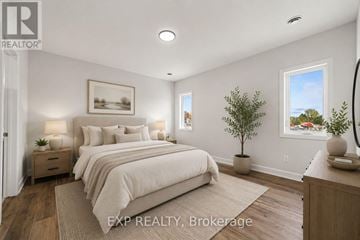 Russell apartment for rent - A bedroom with a large bed and a small tree in a pot.